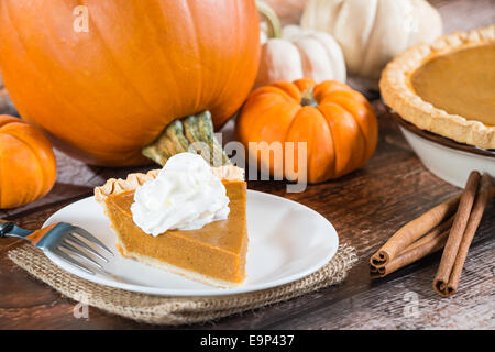 Une tranche de tarte à la citrouille et le potiron sur table en bois Banque D'Images