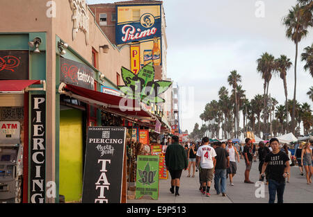 Promeneurs sur célèbre promenade de Venice Beach, à côté du magasin de tatouage et de la marijuana médicale clinique - Los Angeles, Californie Banque D'Images