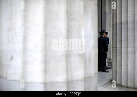 Thessalonique, Grèce. 31 octobre, 2014. La garde des agents de police de protestation devant la direction générale de la Banque de Grèce. À l'occasion de l'épargne mondiale Journée environ 50 petits obligataires qui ont subi des pertes importantes au cours de l'énorme dette publique radiation sur 2012, affirment avoir été trompés par le gouvernement et demandent une indemnisation. Thessalonique, Grèce le 31 octobre 2014. Credit : Konstantinos Tsakalidis/Alamy Live News Banque D'Images