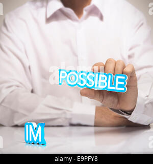 Par rapport au concept de l'impossible possible de la motivation. Un homme tenant la parole possible dans une main avec le préfixe Banque D'Images