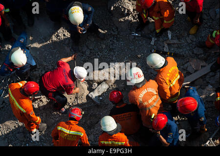 Jakarta, Indonésie. 31 octobre, 2014. Les sauveteurs se rassemblent autour du corps d'une victime lors d'une intervention à Jakarta, Indonésie, le 31 octobre 2014. On croit qu'un bâtiment d'archives s'est effondré vendredi matin, provoquant la mort de quatre travailleurs de la construction, cinq travailleurs gravement blessés et deux membres d'une équipe de sauvetage légèrement blessés lors de la recherche de victimes. Sanovri Crédit : Veri/Xinhua/Alamy Live News Banque D'Images