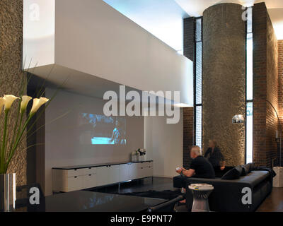 Couple avec projection en salle de séjour de vacances Barbican, Londres, Royaume-Uni. Banque D'Images