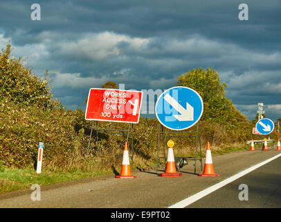 L'accès fonctionne 'uniquement' et avec les cônes de signalisation flèche sur la bande d'arrêt d'urgence de l'autoroute M4, dans le chaud soleil de début de soirée, à l'ouest de Londres, Angleterre, Royaume-Uni. Banque D'Images