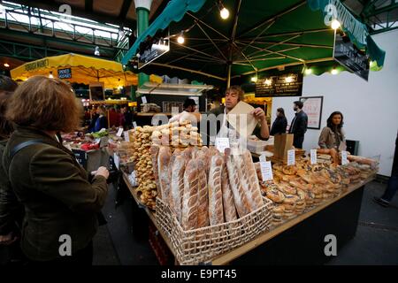 Titulaire d'un décrochage qui sert du pain frais à un client d'un Borough Market, London. 2014 Banque D'Images