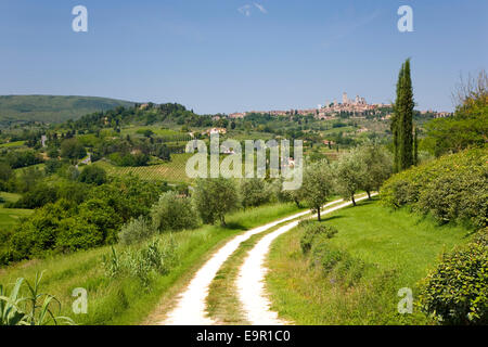 San Gimignano, Toscane, Italie. Voir serpentent le long de la piste agricole médiéval éloigné de la ville. Banque D'Images