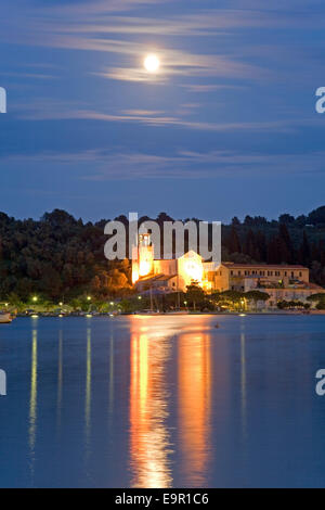 Portovenere, Ligurie, Italie. Voir au clair de lune à travers Harbour à l'allumé Santuario di Nostra Signora delle Grazie. Banque D'Images