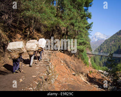 Porteurs sherpa de transporter de grosses charges sur le camp de base de l'Everest Trek Everest, Népal, Région. Banque D'Images