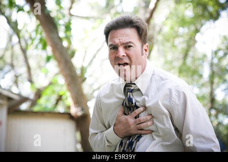 Businessman souffrant à la poitrine ou douleur d'estomac liés à une crise cardiaque, angine, ou autres comme illenss la grippe ou le virus ebola. Banque D'Images