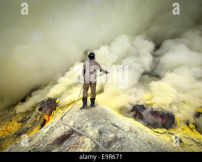 Mineur de soufre utilisé pour les tuyaux de l'extraction du soufre à l'intérieur du cratère du Kawah Ijen volcano, l'Est de Java, Indonésie. Banque D'Images