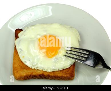 Œuf frit sur du pain grillé avec une fourchette. Banque D'Images