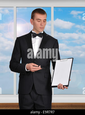 Businessman standing in office holding blank et presse-papiers Banque D'Images