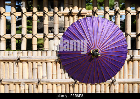 Parapluie rouge traditionnel japonais avec bamboo fence Banque D'Images