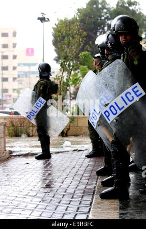 Les forces de sécurité palestiniennes à l'abri d'une forte pluie pour à Bethléem, en Cisjordanie. Les forces de sécurité palestiniennes sont arrivés comme de jeunes Palestiniens protestaient vendredi, en raison de la montée des tensions à Jérusalem. Les forces de sécurité ont tenté de calmer les jeunes. Divers politiciens palestiniens et les dirigeants ont déclaré la journée une "Journée de la Colère" en Cisjordanie. C'est à la suite d'une fermeture sans précédent de la mosquée Al Aqsa le jeudi matin, ce qui était la première fois que le site a été fermé aux saints et fidèles musulmans palestiniens depuis 1967. Il a été ré-ouvert mais des restrictions sévères ont été placés Banque D'Images