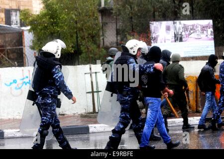 Les forces de sécurité palestiniennes à Bethléem, en Cisjordanie, une escorte de jeunes Palestiniens masqués qui protestait à Bethléem. Divers politiciens palestiniens et les dirigeants ont déclaré la journée une "Journée de la Colère" en Cisjordanie. C'est à la suite d'une fermeture sans précédent d'Al Aqsa le jeudi matin, ce qui était la première fois que le site a été fermé aux saints et fidèles musulmans palestiniens depuis 1967. Il a été ré-ouvert mais des restrictions ont été imposées aux Palestiniens qui tentent d'entrer dans la mosquée. La fermeture de la troisième lieu saint de l'Islam est venu après la tentative d'assassinat d'une aile droite Isra Banque D'Images