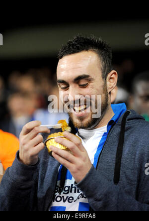 Brighton et Hove Albion football fan de manger une tarte sur les terrasses du rez-de Banque D'Images