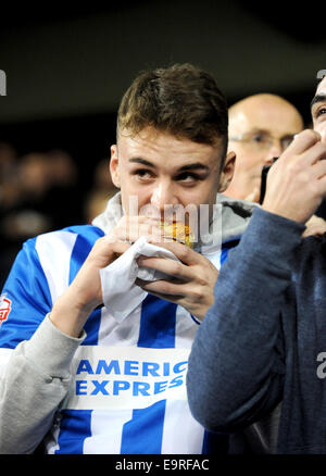 Brighton et Hove Albion football fan de manger une tarte sur les terrasses du rez-de Banque D'Images