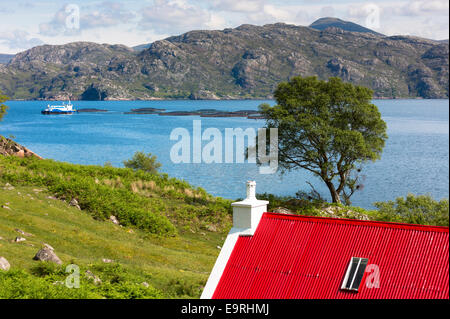 Salmon Farm à Loch Torridon et cottage avec toit en tôle ondulée rouge en Wester Ross dans les Highlands écossais Banque D'Images