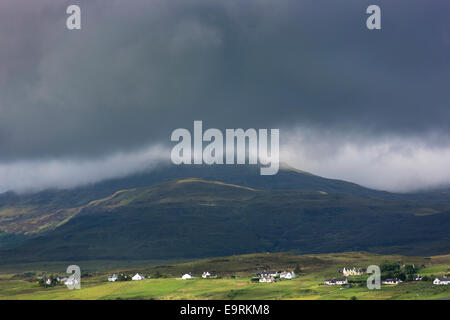 White croft cottages niché sous une montagne et nuages gris près de Harlosh sur l'île de Skye, Western Isles of Scotland, UK Banque D'Images