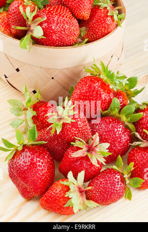 Les fraises dans le panier sur planche de bois Banque D'Images