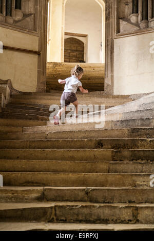 Fille enfant touristiques sur marches en pierre de la cathédrale de Wells ; étapes qui mènent à la Salle Capitulaire / Chapter House. Wells, Somerset. UK Banque D'Images