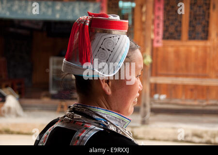 Femme gejia avec coiffe traditionnelle avec orange rouge glands, matang, province de Guizhou, Chine Banque D'Images