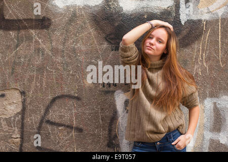 Pretty young fashion girl debout près d'un mur de pierre d'une maison. Banque D'Images