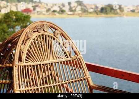 Chaises en osier sur la terrasse d'un restaurant typique donnant sur la 5.32 km2 Lac Phewa tal-au pied de l'Annapurnas éventail Banque D'Images