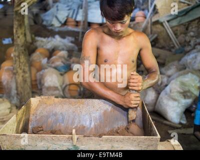 Twante, Division de Yangon, Myanmar. 2e Nov, 2014. Un travailleur se mélange argile dans une usine de poterie à Twante, Myanmar. Twante, à environ 20 milles de Yangon, est mieux connu pour sa poterie traditionnelle. Les décideurs de la poterie ont du mal à maintenir les travailleurs dans leurs cabanes. Le Myanmar s'ouvre à des investissements extérieurs et son économie se développe, les jeunes partent de Yangon à prendre des emplois mieux rémunérés dans l'industrie touristique ou dans les usines qui se multiplient autour de Yangon. © Jack Kurtz/ZUMA/Alamy Fil Live News Banque D'Images