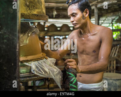 Twante, Division de Yangon, Myanmar. 2e Nov, 2014. Un travailleur tire un pot en argile sur un moule dans un atelier de poterie à Twante, Myanmar. Twante, à environ 20 milles de Yangon, est mieux connu pour sa poterie traditionnelle. Les décideurs de la poterie ont du mal à maintenir les travailleurs dans leurs cabanes. Le Myanmar s'ouvre à des investissements extérieurs et son économie se développe, les jeunes partent de Yangon à prendre des emplois mieux rémunérés dans l'industrie touristique ou dans les usines qui se multiplient autour de Yangon. © Jack Kurtz/ZUMA/Alamy Fil Live News Banque D'Images