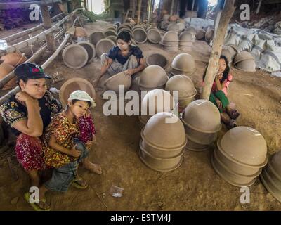 Twante, Division de Yangon, Myanmar. 2e Nov, 2014. Les travailleurs et leurs familles dans une usine de poterie à Twante, Myanmar. Twante, à environ 20 milles de Yangon, est mieux connu pour sa poterie traditionnelle. Les décideurs de la poterie ont du mal à maintenir les travailleurs dans leurs cabanes. Le Myanmar s'ouvre à des investissements extérieurs et son économie se développe, les jeunes partent de Yangon à prendre des emplois mieux rémunérés dans l'industrie touristique ou dans les usines qui se multiplient autour de Yangon. © Jack Kurtz/ZUMA/Alamy Fil Live News Banque D'Images