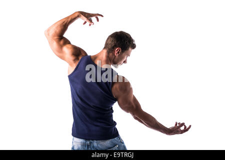 Trouver un homme musclé attrayant pose, montrant le dos, les épaules et les triceps, en t-shirt et jeans on white Banque D'Images