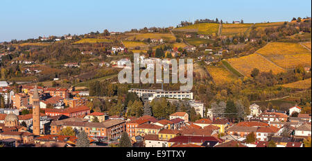 Petite ville et vignobles automnaux colorés sur fond en Piémont, Italie du Nord. Banque D'Images