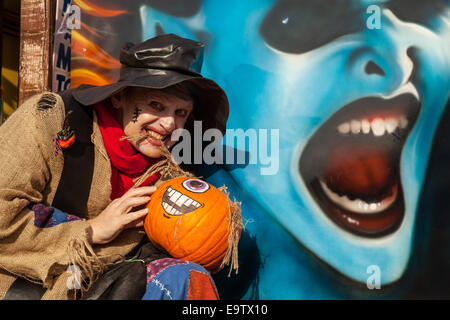 Face bleu sorcière et les droits de l'épouvantail (MR) à Southport, Merseyside, visages peints à la citrouille Halloween event Pleasureland. Le dernier jour de l'ouverture pour la saison 2014 a vu une multitude de personnages, la Citrouille Citrouilles Peinture Peinture, Art, la Citrouille Citrouille Citrouille, idées bricolage, les citrouilles, les potirons sculptés en bois peint, fait face à la citrouille citrouille, les gens sur l'écran. Banque D'Images