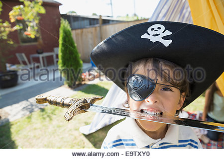 Portrait of boy in pirate hat biting sword