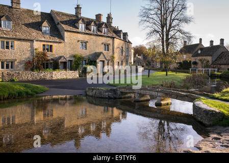 Les chalets et les réflexions de la rivière à l'automne le soleil. Lower Slaughter. Cotswolds, Gloucestershire, Angleterre Banque D'Images