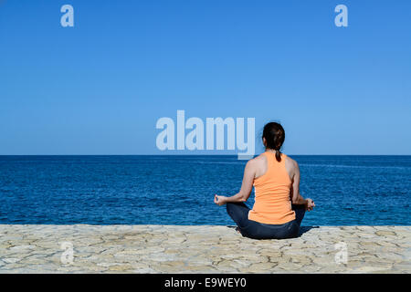 Woman practicing yoga, méditation au bord de la Jamaïque. Banque D'Images