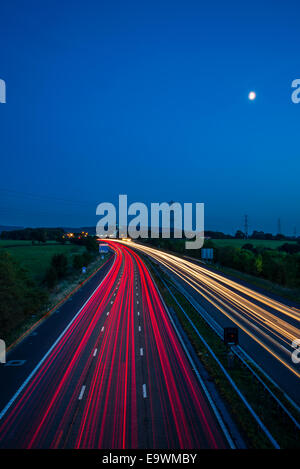 Pleine lune et la lumière des sentiers de la circulation sur l'autoroute M6, près de Lancaster (Forton Lancashire services) Banque D'Images