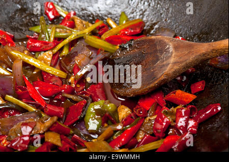 Piment et légumes frits sur un pan wok en fer Banque D'Images