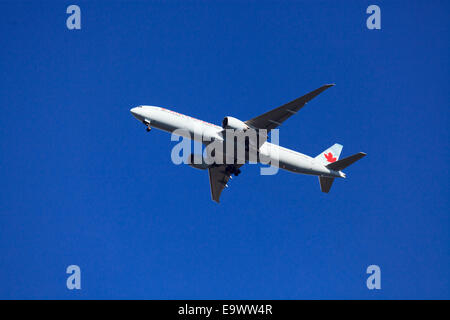 Boeing 777-333 d'Air Canada(ER) du dessous contre ciel bleu avec le train roulant Banque D'Images