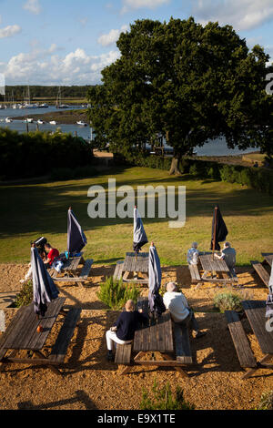 Regardant vers le bas sur les gens assis à des tables banc pub soirée de lumière du soleil à Milford On Sea Banque D'Images