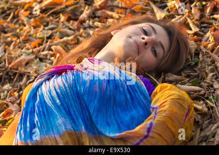 Portrait de jeune femme avec un foulard coloré sur les feuilles, extérieur shot Banque D'Images