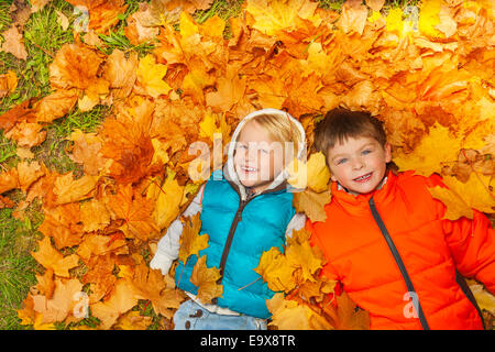 Deux garçons portant sur les feuilles de l'automne Vue de dessus Banque D'Images