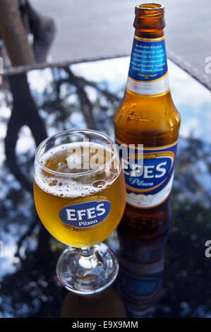 Un verre et une bouteille de bière turque de la FEAS, Bodrum, Turquie, verres de boissons table pub Banque D'Images