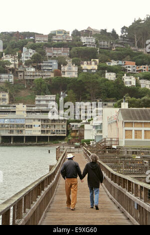 Vieux couple marche main dans la main sur Sausalito en Californie pier Banque D'Images