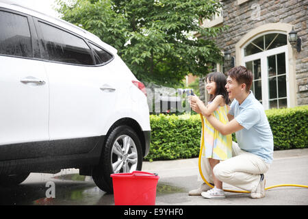 Girl aider père voiture nettoyage Banque D'Images