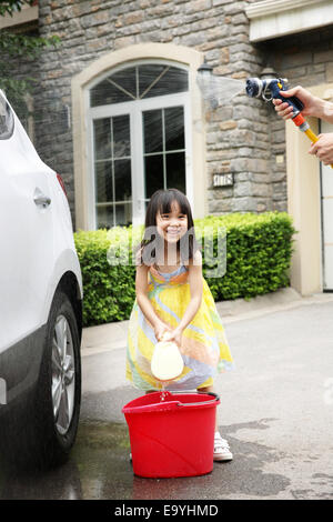 Girl aider père voiture nettoyage Banque D'Images