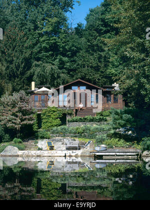 Maison sur la colline par le lac en été Banque D'Images