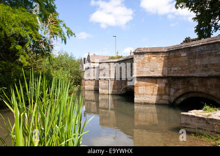 La rivière Windrush coule sous le vieux pont de pierre dans la ville de Cotswold Burford Oxfordshire, UK Banque D'Images