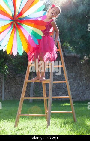 Girl putting up décoration dans jardin Banque D'Images