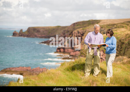 Couple reading map, Chemin de la côte près de Marloes, Pembrokeshire Coast National Park, Pays de Galles, Royaume-Uni Banque D'Images